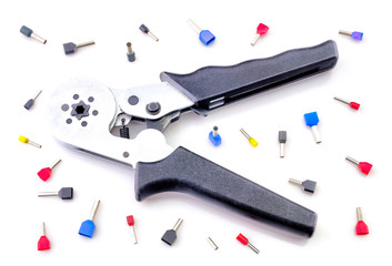 Crimping tool and electrical connectors isolated on white background closeup