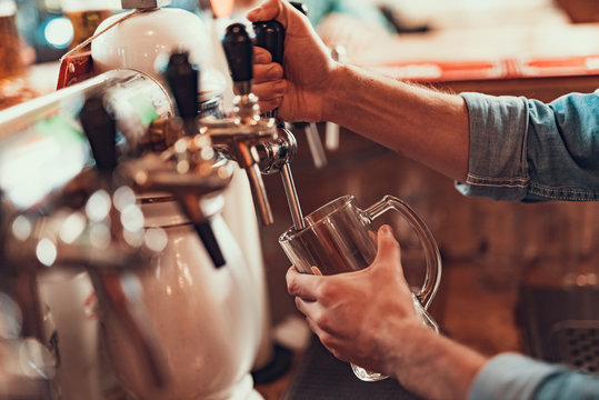 Bartender Pouring Beer From Tap In Pub