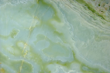 Fragment of natural polished Verde Onyx stone of green color with stains and streaks