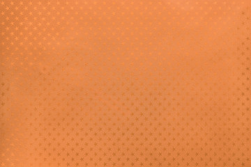 Orange background from metal foil paper with a stars pattern