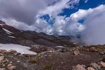blue sky and clouds rolling over mountain top