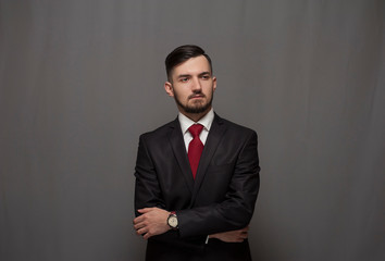 Portrait of serious confident businessman posing against gray background