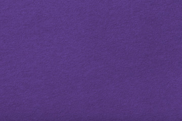 Dark purple matt suede fabric closeup. Velvet texture of felt.