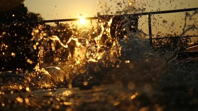 Silhouette of young man jumps in swimming pool water at Sunset through the sun. slow motion. 1920x1080