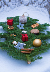 weihnachtsdekoration auf einem tannenzweig im schnee