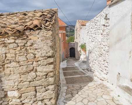 Old narrow street with traditional stone houses in Village Krini, corfu, greece