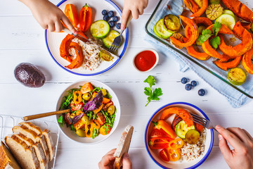 Family eating a healthy vegetarian food. Vegan lunch table top view, plant based diet. Baked...
