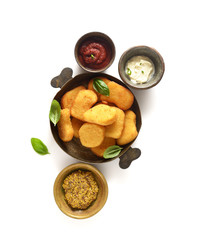Fried chicken nuggets in a pan with basil leaves, ketchup and sauce on a white background. Top view.