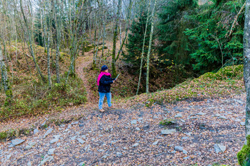 Obraz premium beautiful image of a woman looking at a paper map to verify the way to the hil Bec du Corbeau on a wonderful and cold autumn day in the Belgian Ardennes