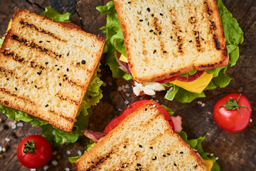 Three sandwiches on a wooden background, top view
