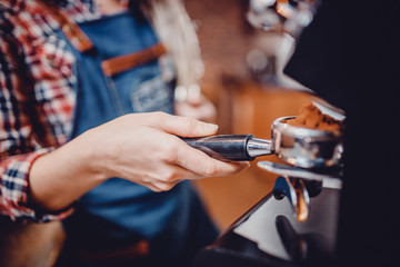 Hands baristas holding fine grinding of coffee for espresso.