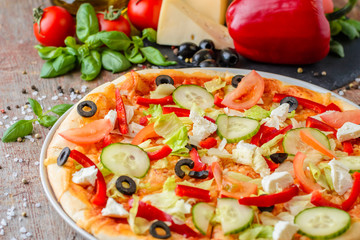 Italian pizza with ingredients on a wooden background, close up