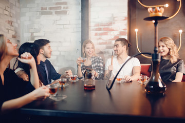 Best friends meet in Shisha cafe, drink tea, chat, smoke hookah, laugh