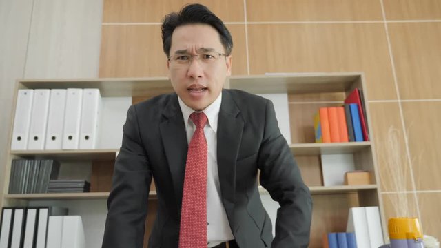 Angry businessman scolding and yelling at camera in Office. Slow motion.