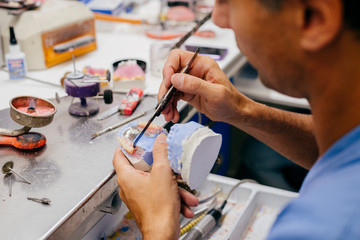 Obraz na płótnie Canvas Caucasian man working on a dental prosthesis