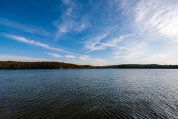 blue sky white clouds over calm body of water