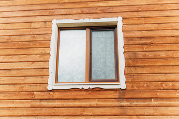 The window in the wooden wall of wooden house