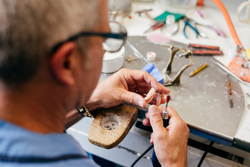 Fototapeta na wymiar Caucasian man working on a dental prosthesis