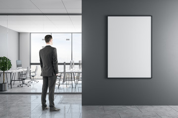 Fototapeta premium Businessman in modern office with poster