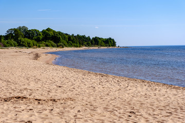 lakeside beach details with sand, rocks and blur background