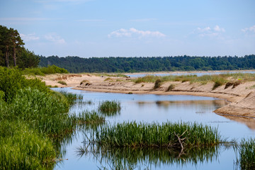 lakeside beach details with sand, rocks and blur background