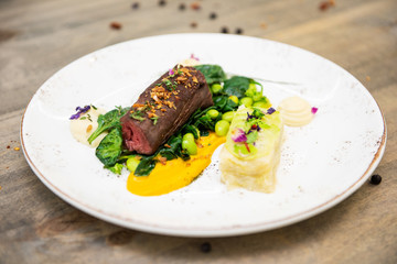 Beef meat with green peas, sweet potato mousse, roasted spinach and zucchini gratin