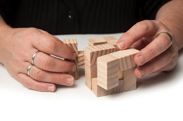 closeup of woman hand with wooden puzzle  on white table background
