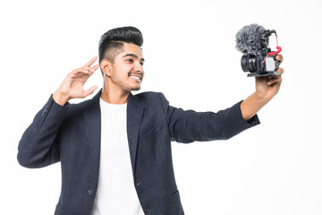 Young indian man blogger capture himself for video blog on his chanel on camera isolated on white background