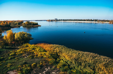 River, blue sky and forest. Picturesque sunny autumn landscape