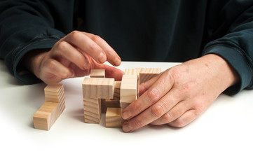 closeup of man hand with wooden puzzle  on white table background