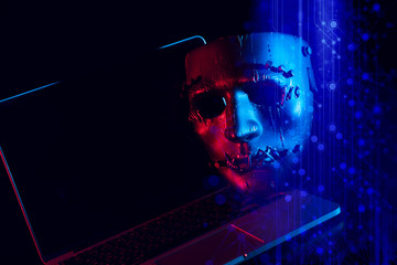 devil hacker mask face ghost with laptop computer in security network anti-virus concept with laser hologram