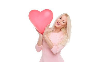Fototapeta na wymiar Beautiful young blond woman with heart shape pink air balloon on white isolated background. Woman on Valentine's Day. Symbol of love - Image