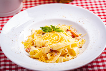 Italian cuisine. Pasta carbonara with bacon, cheese and egg on white plate. Close up