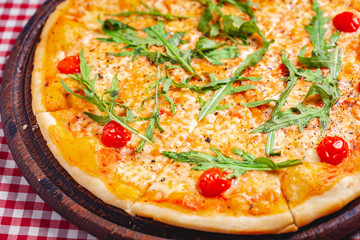 Pizza Margherita (Margarita) with fresh arugula on wooden board. Close up