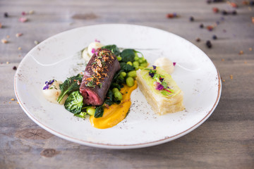 Beef meat with green peas, sweet potato mousse, roasted spinach and zucchini gratin