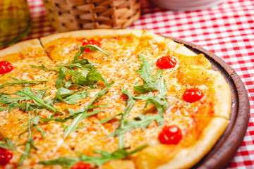 Pizza Margherita (Margarita) with fresh arugula on wooden board. Close up