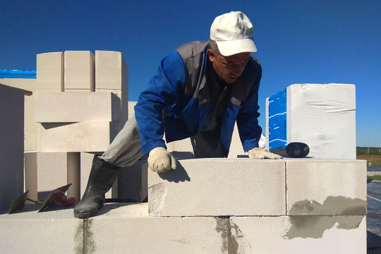 The worker checks the wall of gas blocks by a leveler
