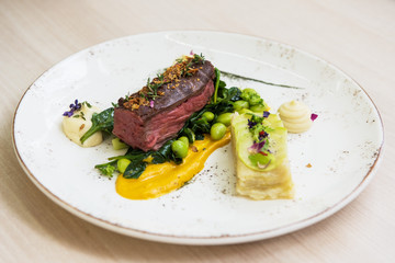 Beef meat with green peas, sweet potato mousse, roasted spinach and zucchini gratin