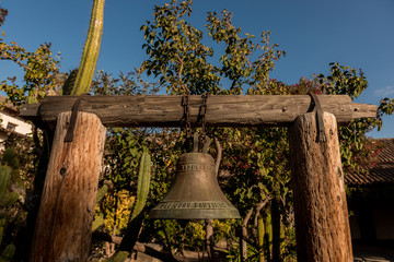 Bell in courtyard of San Juan Bautista mission , California, USA.