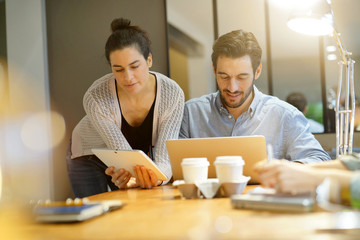 Attractive colleagues sharing business ideas in co working space