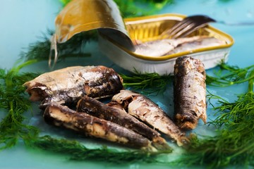 Canned sardines, open tin and dill.