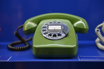 Old-fashioned retro 1960`s phone on blue background 