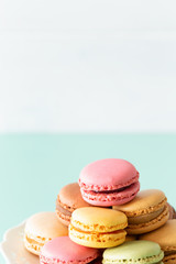 macaroons cake in soft colors on the pastel green glass background.