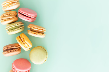 macaroons cake in soft colors on the pastel green glass background.