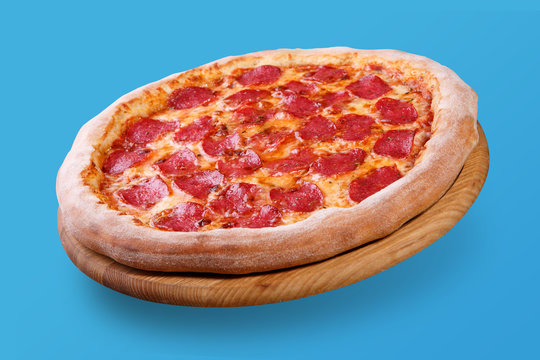 Italian Pizza Floating In The Air With Cheese And Salami, On Pastel Blue Background, Food