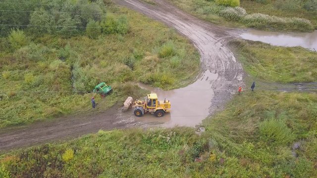 Tractor tows car. Clip. Top view of SUV, descended from race track, lost control, taken to tow tractor. Dangerous situation in off-road racing