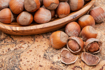 Fresh organic high quality hazelnuts, filberts in wooden bowl on natural cork background.