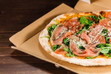 Pizza with ham and vegetables on wooden table