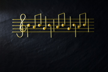 Musical Christmas sheet music paste isolated on a black textural background.