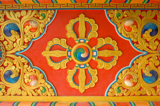 a colorful bright red yellow blue Buddhist vajra image on the wall of the temple. sacred images
